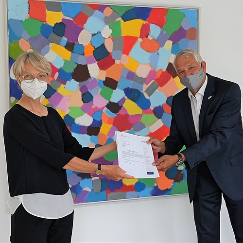 Regierungspräsidentin Dorothee Feller (links) überreicht den Förderbescheid an Bürgermeister Wilhelm Sendermann (rechts); Foto: Bezirksregierung Münster